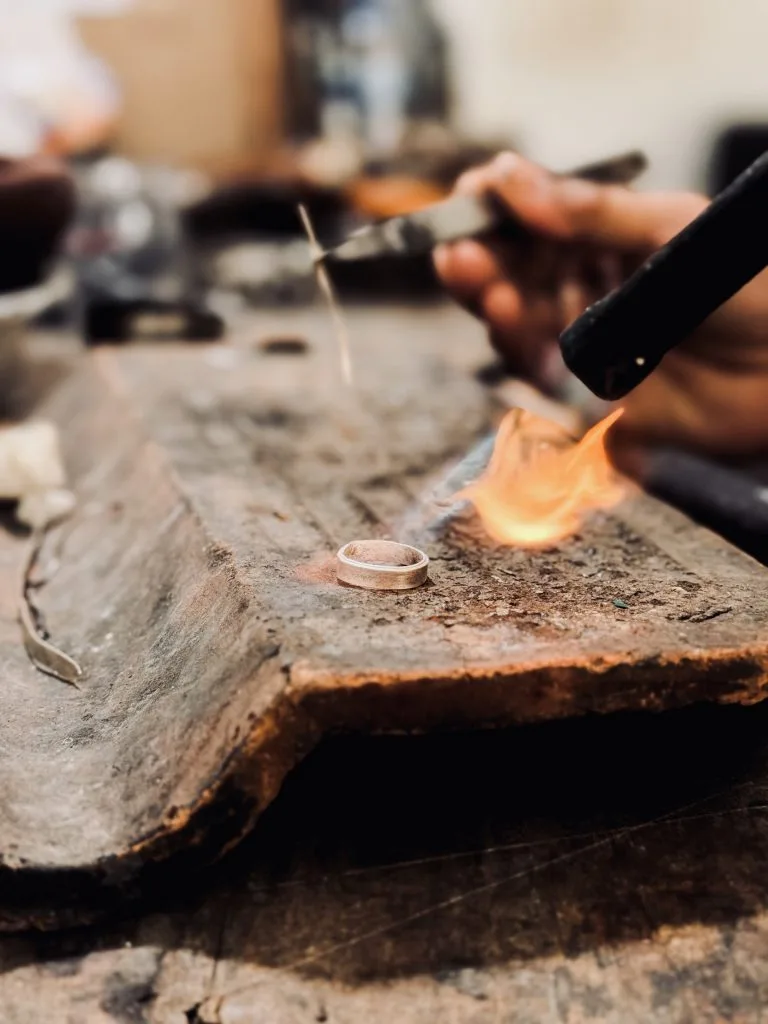Silversmith guiding a guest through a silver making class in Sanur, Bali